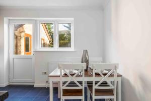 uma sala de jantar com uma mesa de madeira e 2 cadeiras em 2 bedroom House-Driveway - Bournemouth Hospital - Long Stay Discounts - Lima Apartments Ltd em Bournemouth