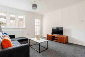 a living room with a couch and a flat screen tv at 2 bedroom House-Driveway - Bournemouth Hospital - Long Stay Discounts - Lima Apartments Ltd in Bournemouth