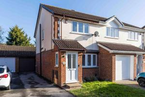 a brick house with a white door and a garage at 2 bedroom House-Driveway - Bournemouth Hospital - Long Stay Discounts - Lima Apartments Ltd in Bournemouth