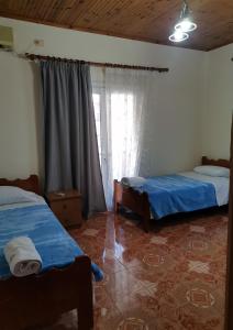 sypialnia z 2 łóżkami i oknem w obiekcie Margarita - Entire house with 4 bedrooms and free parking w Gjirokastrze