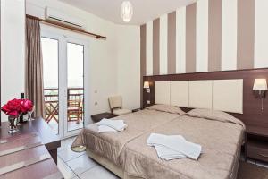 スコペロスにあるAkti Fine Roomsのベッドとバルコニー付きのホテルルーム