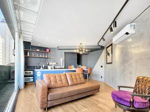 a living room with a couch and a kitchen at Lindo apartamento ao lado Shop Frei Caneca e do Parque Augusta in Sao Paulo
