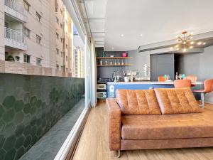 a living room with a couch and a kitchen at Lindo apartamento ao lado Shop Frei Caneca e do Parque Augusta in Sao Paulo