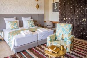 a hotel room with a bed and a chair at Al Destino Villa Riad Spa Luxury Marrakech in Marrakesh