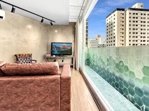 a living room with a couch and a large window at Lindo apartamento ao lado Shop Frei Caneca e do Parque Augusta in Sao Paulo +26 photos