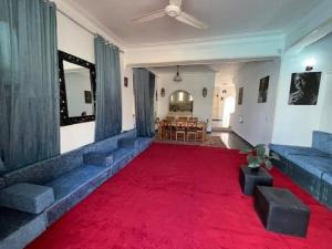 sala de estar con alfombra roja y comedor en Prime location family beach villa - 16 pax, en Alejandría