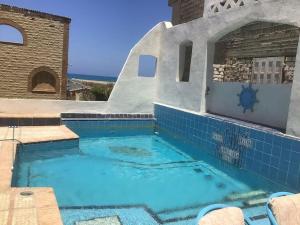 duży basen w domu z niebieskimi płytkami w obiekcie Prime location family beach villa - 16 pax w Aleksandrii