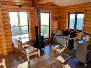 a log cabin living room with a couch and chairs at Private Mountain Log Cabin with amazing panoramic sunset views at small scale nature resort in Cabeceiras de Basto
