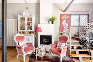 a living room with two chairs and a staircase at Garden Loft in Baricella