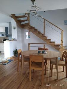 een eetkamer met een tafel en een trap bij Maison rénovée atypique, jardin, terrasse, Odet in Quimper