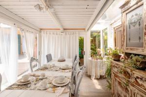 a white dining room with a table and chairs at Garden Loft in Baricella