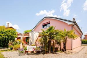 a pink house with palm trees in front of it at House Garden Loft in Baricella