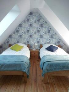 two beds in a room with a attic at Maison rénovée atypique, jardin, terrasse, Odet in Quimper
