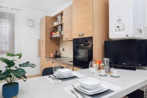 a kitchen with a table with plates and wine glasses at Loft - Comfort Studio - [10m Piazza Maggiore] in Bologna