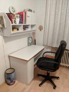 escritorio y silla negra en una habitación en Praktisches Gästezimmer für eine Person, en Bergisch Gladbach