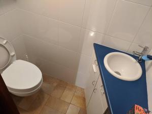a bathroom with a white toilet and a sink at Praktisches Gästezimmer für eine Person in Bergisch Gladbach
