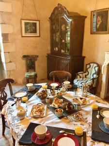 una mesa con comida y platos. en Chambres d'hôtes La Borderie du Gô près de La Rochelle - Nieul, en Nieul-sur-Mer
