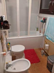 y baño con ducha, aseo y alfombra roja. en Praktisches Gästezimmer für eine Person, en Bergisch Gladbach