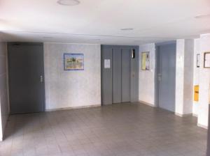 a hallway with gray doors and tile floors at Appartement T2 climatisé 4 personnes piscine et parking privée in Sète