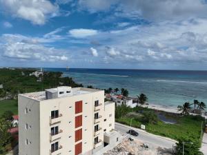 ein Apartmenthaus mit dem Meer im Hintergrund in der Unterkunft Oneiro Suites with Sea View in Mahahual