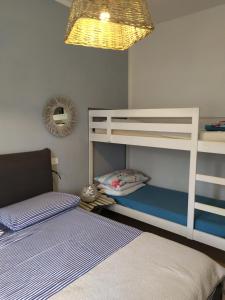 1 dormitorio con 2 literas y lámpara en Bilocale a 40 mt. dalla spiaggia circondato dalla pineta, en Marina di Grosseto