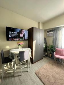 a living room with a table and a tv on the wall at Staycation @ AMAIA SJDM Bulacan in Tunkong Manga