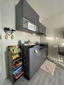 a kitchen with a black refrigerator and a microwave at Staycation @ AMAIA SJDM Bulacan in Tunkong Manga