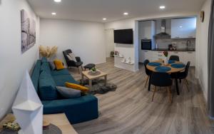 a living room with a blue couch and a table at Apartman DUJIĆ Vinkovci in Vinkovci