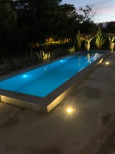 a swimming pool with lights in a backyard at night at Casa Quinta en Aregua in Patiño