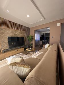 a living room with a large couch and a flat screen tv at Villa Ana in Kastel Sucurac
