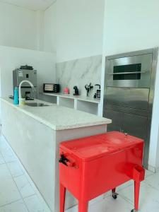 a kitchen with a red stool at a counter at Casa Quinta en Aregua in Patiño
