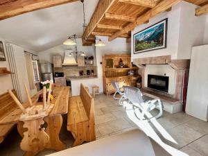 a kitchen with a wooden table and a fireplace at Chalet Paradisi in Castello Tesino