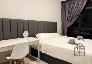 Schlafzimmer mit einem Bett, einem Tisch und einem Schreibtisch in der Unterkunft Jesselton Quay CityView @NeoStay in Kota Kinabalu