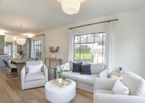 uma sala de estar com um sofá branco e cadeiras em 3917 Casa Blanca home em Pacific Grove