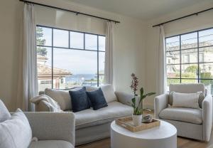 uma sala de estar com um sofá e cadeiras e uma grande janela em 3917 Casa Blanca home em Pacific Grove