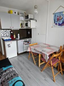 - une petite cuisine avec une table et des chaises dans la chambre dans l'établissement studio 4 pers Puy-Saint-Vincent 1700, à Puy-Saint-Vincent