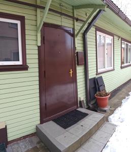 een groen huis met een bruine deur erop bij Cozy 1-bedroom apartment in the heart of Jurmala in Jūrmala