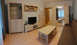 een woonkamer met een bank en een tv bij Cozy 1-bedroom apartment in the heart of Jurmala in Jūrmala