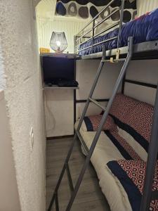 a bunk bed with a television in a room at studio 4 pers Puy-Saint-Vincent 1700 in Puy-Saint-Vincent