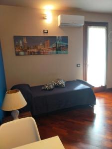 ein Schlafzimmer mit einem Bett, einem Tisch und einer Lampe in der Unterkunft Mini appartamento con giardino in Fontanafredda