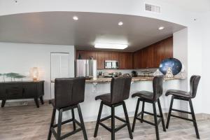 a kitchen with four bar stools and a counter at Aqua 801 in Panama City Beach