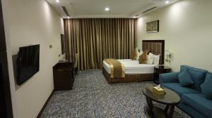 a hotel room with a bed and a couch at فندق اللوتس in Najran