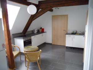 a kitchen with white cabinets and a table and chairs at Wohnwerk41 in Schwäbisch Hall