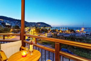 a table on a balcony with a view of a harbor at Akti Fine Rooms in Skopelos Town