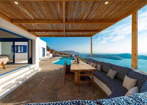 an outdoor patio with a couch and a table at Luxury Villa Orea, Elounda (owner's listing) in Epáno Eloúnda
