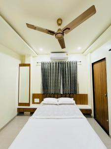 a bedroom with a bed and a ceiling fan at HOTEL EKANT FAMILY RESTAURANT AND LODGING in Daulatābād