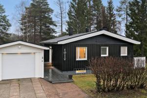 a black house with a white garage at The White and Black House in Kalix
