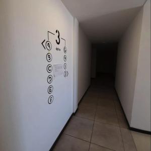 a hallway with a sign on the wall in a room at Home Alojamientos Temporales in San Luis