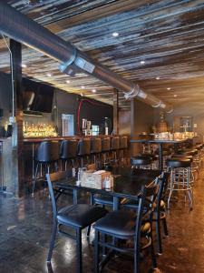 a restaurant with tables and chairs and a bar at The Honey Bee Motel in Dunlap