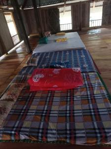 two beds sitting in a room with a rug at Pù Luông Jungle Homestay in Pu Luong
